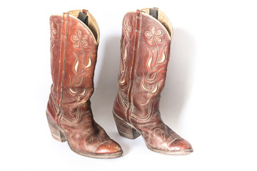 Old dirty cowboy boots on a white background