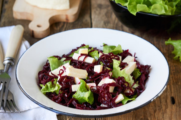 Beet salad with cheese and lettuce in a white bowl