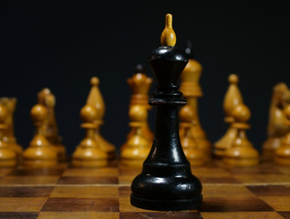 Business problems, leader decision in competition. Chess king opposite white chess.