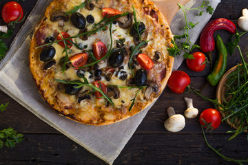 Pizza served with dill. Pizza with tomatoes black olives and ham.