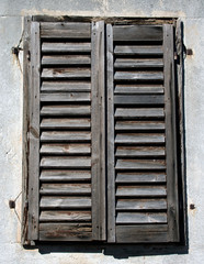 Old rustic wooden blinds on a window frame