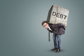 Businessman bending under a heavy stone with the word DEBT on it