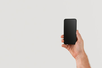 male cuacasian hand holding cell or mobile phone with blank screen and copy space
