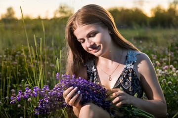 Naklejka premium Girl in a field of purple lupines