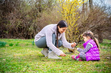 Fototapeta premium Mother daughter relationship - spending time together in the garden, picking flowers