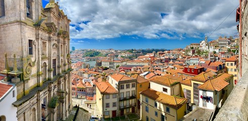Fototapeta premium Panorama of the city of Porto with traditional architecture and terra cotta roof tiles and a blue sky with dramatic clouds