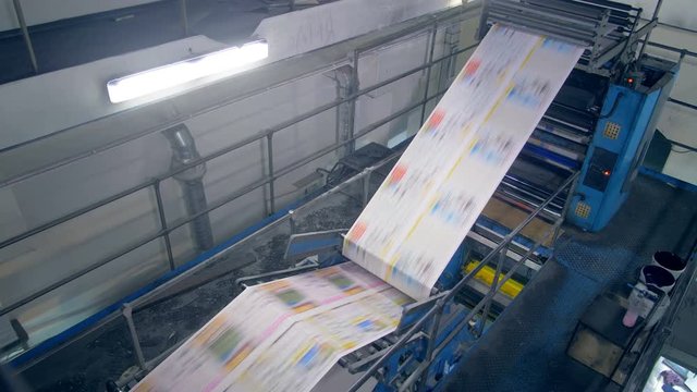 Fresh printed newspaper moving through the printing press