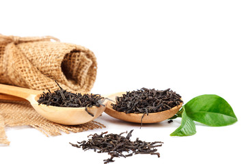 Black tea in a wooden spoon isolated on white background