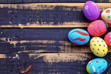 Colorful hand painted easter eggs with pink distress wooden background, pastel color eggs, each...