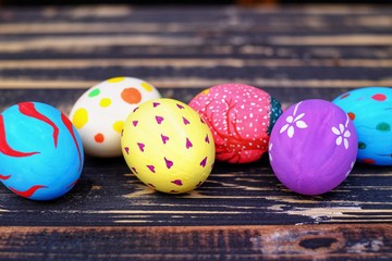 Colorful hand painted easter eggs with pink distress wooden background, pastel color eggs, each...