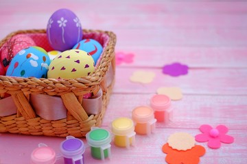 Colorful hand painted easter eggs with pink distress wooden background, pastel color eggs, each...