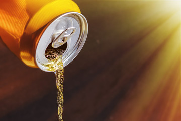 beer pours from the can in the sunlight