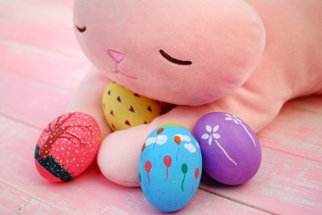 Colorful hand painted easter eggs with pink distress wooden background, pastel color eggs, each...