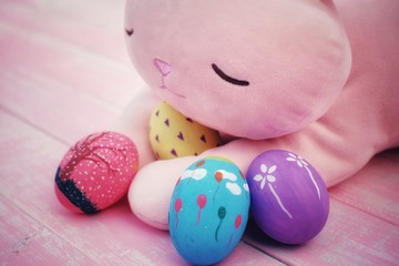 Colorful hand painted easter eggs with pink distress wooden background, pastel color eggs, each...