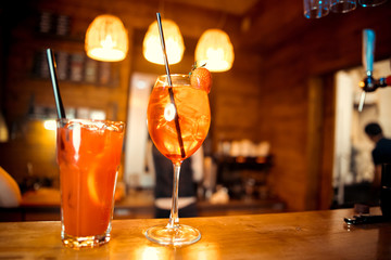 glasses of cocktails on the bar. bartender pours a glass of sparkling wine with Aperol.