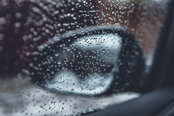 water drops on glass. rearview mirror in the rain.