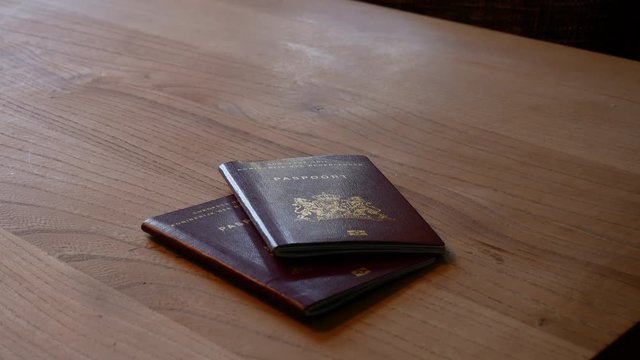 2 passports putting on table slowly
