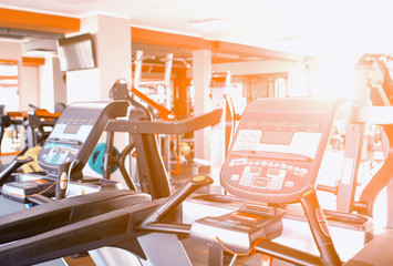 Modern treadmills in the gym for cardiovascular exercise and running, reducing weight against the windows with the sun, running track