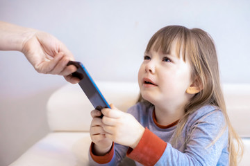 Mother taking away smartphone from her daughter