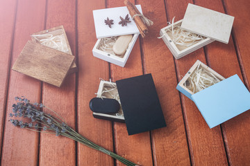 Fototapeta na wymiar Decorative wooden box for presents, memory sticks or money. Ecological friendly package for wrapping. Lavender, anise-tree stars and cinnamon lying nearby. Rustic vintage style.