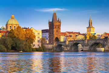 Obraz premium Malowniczy widok na rzekę Wełtawę, most Karola i historyczne centrum Pragi, budynki i zabytki starego miasta o zachodzie słońca, Praga, Czechy