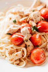 Grilled lean chicken strips with fresh herbs and pepper and sautéed and glazed cherry tomatoes on Italian Linguine or Fettuccine pasta topped with grated parmesan cheese, healthy, low calorie dish