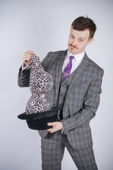young man in a business suit pulls out leopard bra from his hat, but he wanted tricks with wonder...