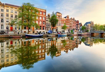 Foto auf Glas Schöner Amsterdamer Sonnenuntergang. Typische alte holländische Häuser auf der Brücke und den Kanälen im Frühjahr, Niederlande © TTstudio