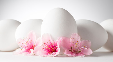 Fototapeta na wymiar white eggs with peach flowers