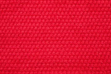 Seamless red knitted fabric background. Close-up.