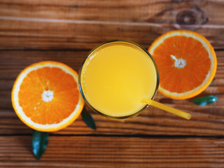 Fresh orange juice in glass on wooden background