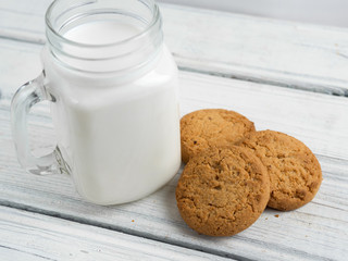 Milk with cookies on wooden white background