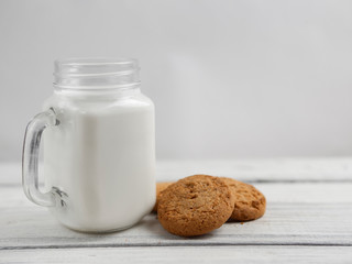 oatmeal cookies with milk on wooden background