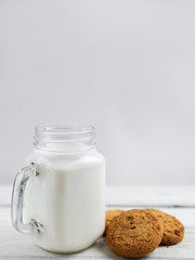 oatmeal cookies with milk on wooden background