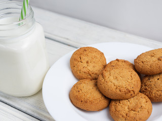 oatmeal cookies with milk on wooden background