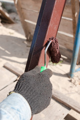 worker's hand paints a metal