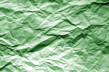 Crumpled sheet of paper in green color.