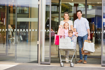 Glückliche Familie und Kinder im Einkaufswagen