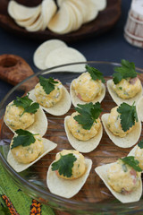 Appetizer on chips with salmon, eggs and cheese