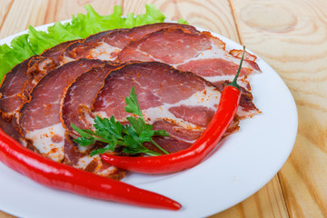 Sliced dried pork neck with greens and chili on dish