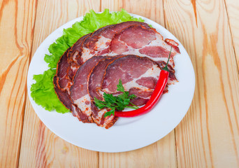 Sliced dried pork neck with greens and chili on dish