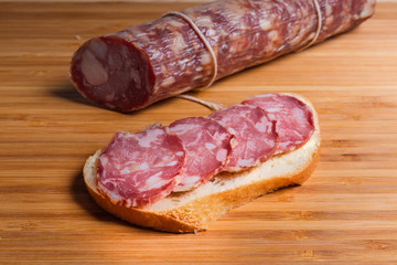 Open sandwich with dry-cured sausage and not sliced sausage