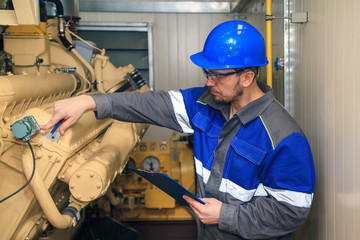 Electromechanic performs repair work on a diesel generator