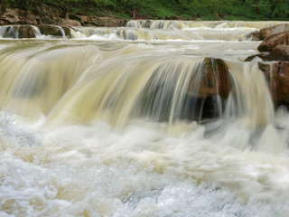 Fototapeta na wymiar Multi-level waterfall on mountain river after rains closeup, Carpathians