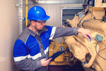 Electromechanic performs repair work on a diesel generator