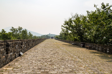 Fototapeta na wymiar May 2017 - Nanjing, Jiangsu, China - a section of the old Ming Dynasty city walls near Jiming temple. Zijin mountain is visible far away. Nanjing has one of the best preserved city walls of China