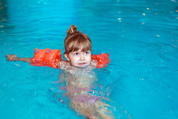  little girl learn to swim in the pool