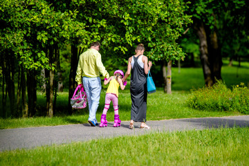 Parents teach their daughter to roller skate 