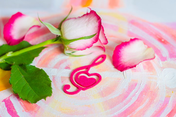 Rose with a decorative heart in the shape of a treble clef with pink felt.