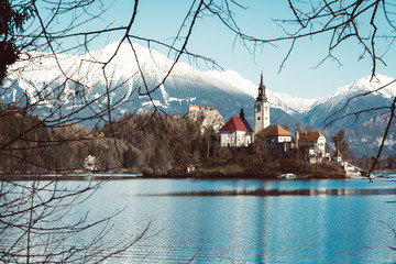 church of assumption in lake bled with snowy mountains in the background. Slovenian winter landscape